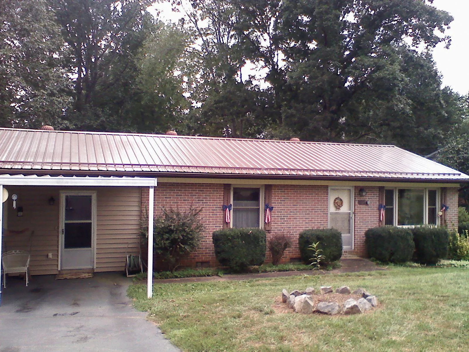 Bronze metal roof and carport on a brick ranch home — Roof Repair work by our crew in Mottville